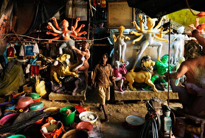 An artist walks by idols of Hindu warrior goddess. ? Photo by AP