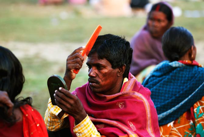 An Indian landless tribal villager combs his hair in the morning in Agra. ? Photo by AP