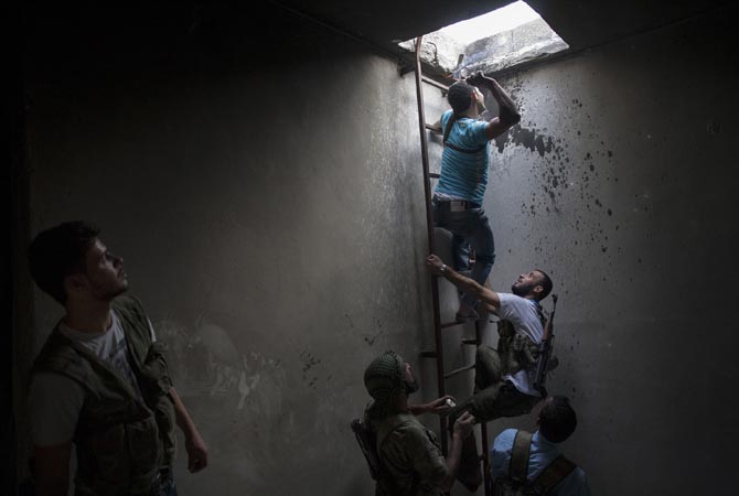 Syrian rebels observe as a comrade prepares to throw a homemade grenade towards an army position in the Al-Amariya district of the northern city of Aleppo. International peace envoy Lakhdar Brahimi pressed in Damascus for a truce to break the cycle of bloodshed in Syria, while the regime said a national dialogue free of foreign interference was the key. ?AFP Photo