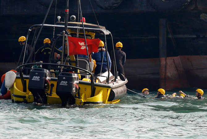 Frogmen from firefighting team retrieve a body, right, near a boat, unseen, after it collided and sank Monday night near Lamma Island, off the southwestern coast of Hong Kong Island. ? Photo by AP