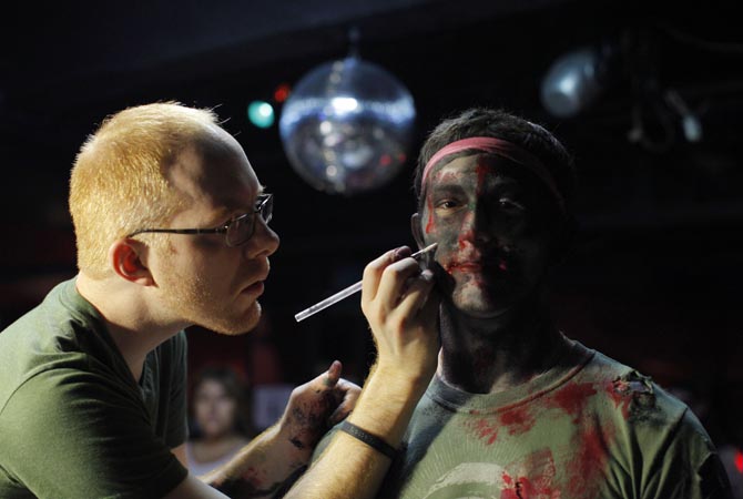 A man dressing up as a zombie has make up applied on him during an event in New York.?Reuters Photo