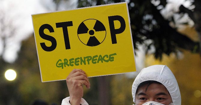 A Greenpeace activist holds a placard during a demonstration outside Japan's PM Noda's official residence in Tokyo, criticizing the government's declaration of cold shutdown at the Fukushima nuclear power plant