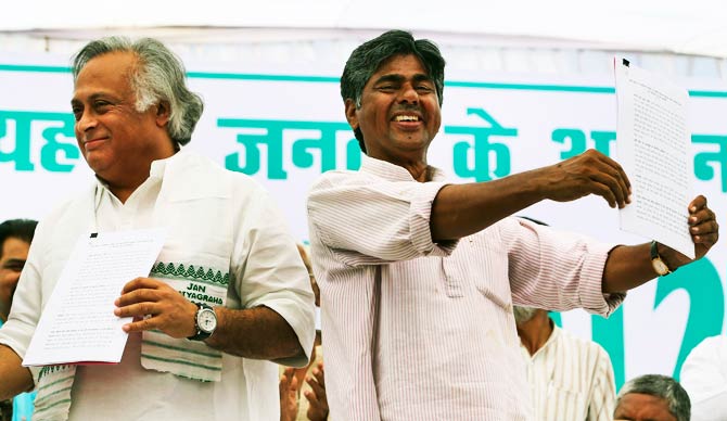 Jan Satyagraha leader P.V. Rajagopal and Indian Rural Development Minister Jairam Ramesh display documents after signing an agreement in Agra. ? Photo by AP