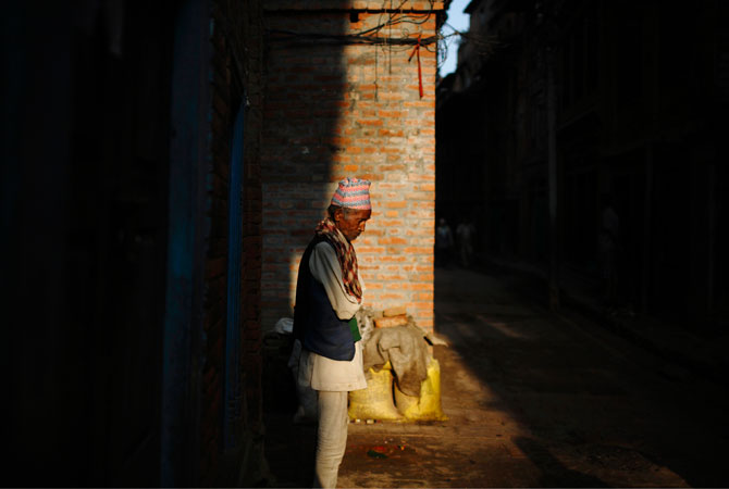 A man stands in the early morning sun in the ancient Nepalese city of Bhaktapur.