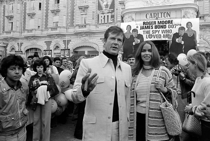 In this May 20, 1977 file photo, actor Roger Moore, alias British secret agent James Bond, is accompanied by co-star Barbara Bach as they arrive for the screening of their latest 007 feature, “The Spy Who Loved Me,” during the Cannes Film Festival at the French Riviera. Moore, played Bond in seven films, more than any other actor.