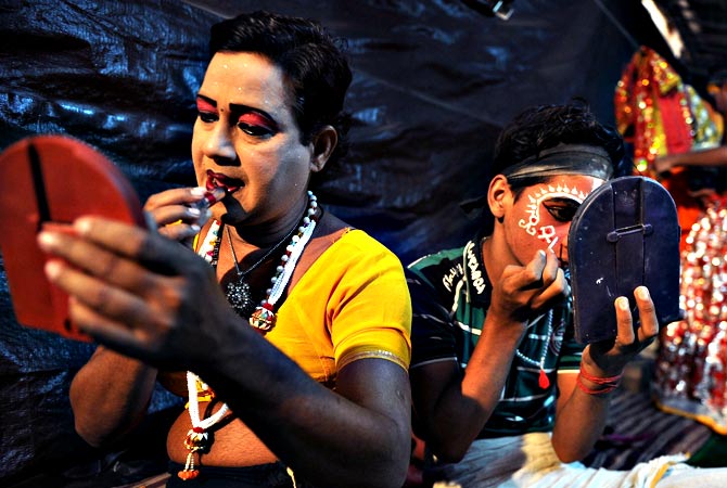 Indian male artist Ram Vilas (L), 42, and junior artist Ajay Kumar, 15, prepare for a show backstage at the Maharashtra Ramlila Manch