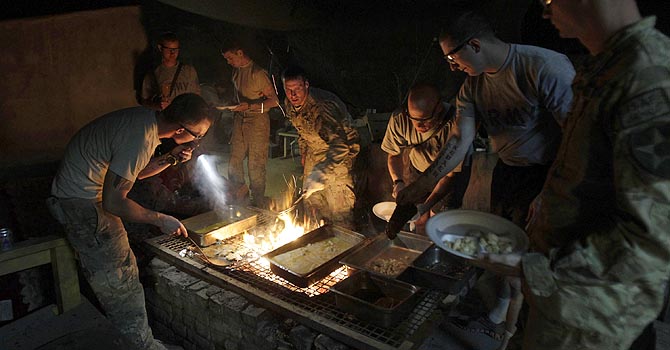 U.S. Army soldiers of HHC-Mortars, 2nd Battalion, 1st Infantry Regiment cook their meal in a pit in Arghandab Valley