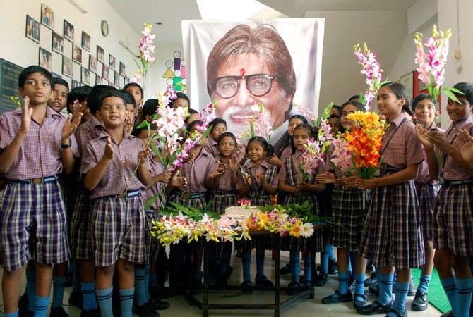 Indian schoolchildren stand in front of a portrait of Bollywood's biggest star Amitabh Bachchan, at an event a day ahead of his 70th birthday, in Mirzapur, India, Wednesday, Oct. 10, 2012. ? Photo by AP