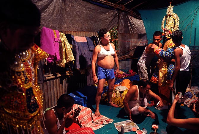 Indian male artist Laxmi Kant Chaturvedi (C), portraying the female character of ?Kaikeyi? prepares backstage before a show at the Sahitya Kala Manch.