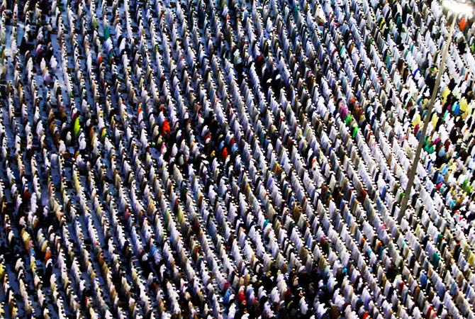 Pilgrims attend a prayer session along a street. ? Photo by Reuters