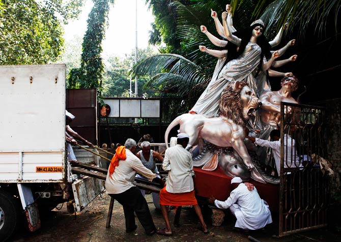 Indians load an idol of Hindu Goddess Durga into a truck to be transported to a place of worship, at a workshop. ? Photo by AP