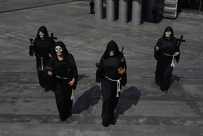 People in skull masks walk near an altar assembled in homage of people who died of diabetes and obesity, during a demonstration in front of the Mexican Ministry of Health in Mexico City. The walk was part of the Day of the Dead.