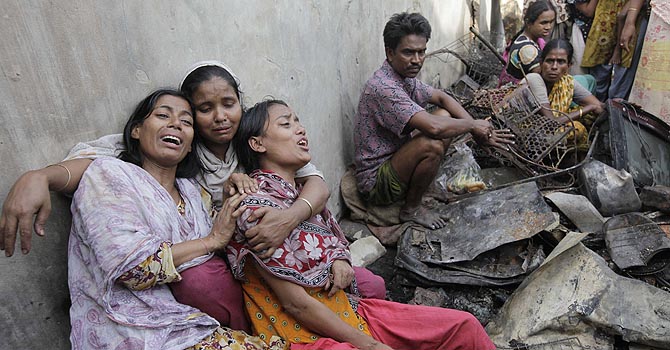 Daughters of Anwara Begum, 60, mourn her death after a fire at a slum at Hazaribagh area in Dhaka