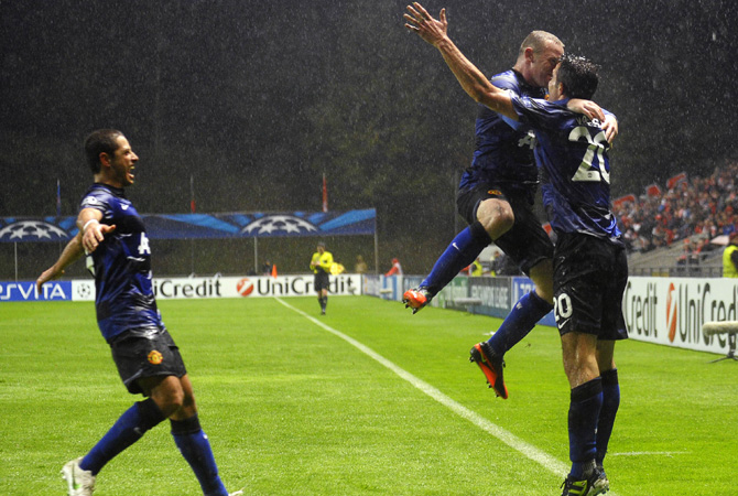 Manchester United's English forward Wayne Rooney (Centre) celebrates with his teammates Mexican forward Javier Hernandez (Left) and Dutch forward Robin van Persie (Right) after scoring a goal during the UEFA Champions League football match SC Braga vs Manchester United at the Municipal stadium of Braga.