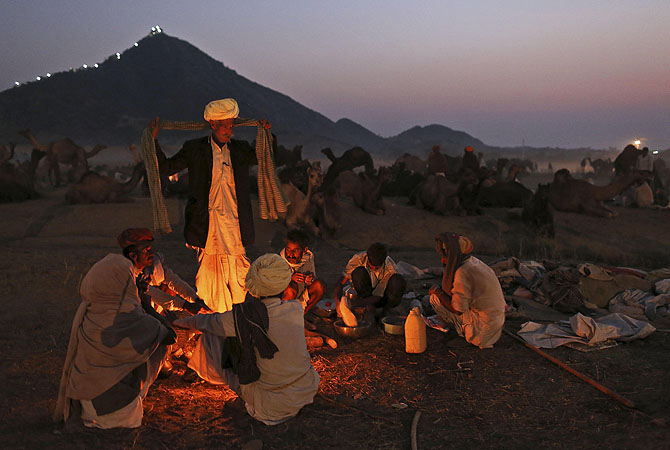 Indian camel herders sit around a fire at the annual Pushkar Fair in Pushkar, Rajasthan, India.?Photo by AP