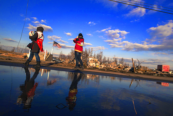 Red Cross volunteers walk past the remaining foundations of homes destroyed by the storm surge of superstorm Sandy in the Staten Island borough neighborhood of Oakwood in New York.?Photo by Reuters
