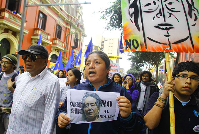 Demonstrators shout slogans against Peru's former president Alberto Fujimori during a protest in downtown Lima. Fujimori, currently in prison for human rights crimes and suffering from oral cancer, has asked President Ollanta Humala for a humanitarian pardon. The placard reads: "No to a pardon".?Photo by Reuters