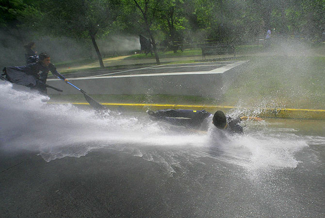 Students protester are hit by a jet of water as they clash with riot police officers during a rally demanding that the government makes changes to the public state education system in Santiago.?Photo by Reuters