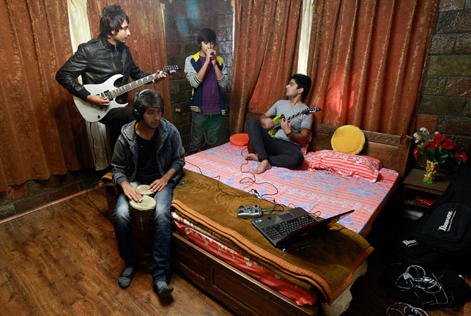 Members of the band ?Sign - the signature of music? (L-R) guitarist Zahoor Qadir, 18, drummer Muneeb Khan, 17, guitarist and lead singer Qassam Dar, 18, and guitarist Azan Mullick, 18, record a song at Azan's home in Srinagar.