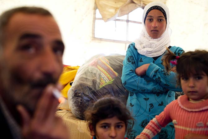 A family gathers inside a tent after arriving to the Turkish side of the Orontes river after fleeing from the northern Syrian town of Darkush.