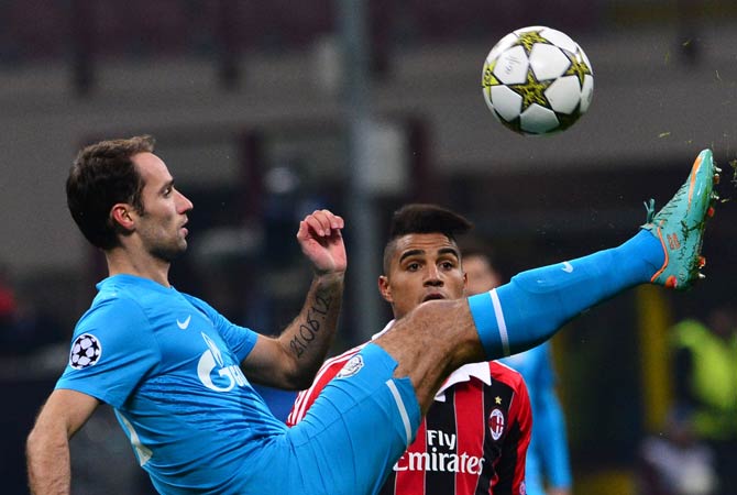 FC Zenith's midfielder Roman Shirokov (Left) fights for the ball with AC Milan's Ghanaian defender Prince Kevin Boateng during the Champions League match AC Milan vs FC Zenith.
