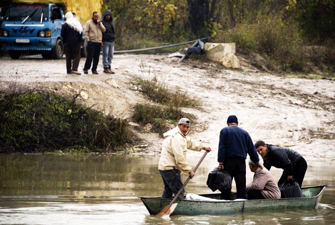 Syrians flee aboard a boat across the Orontes river near the northern Syrian town of Darkush to go to neighbouring Turkey.