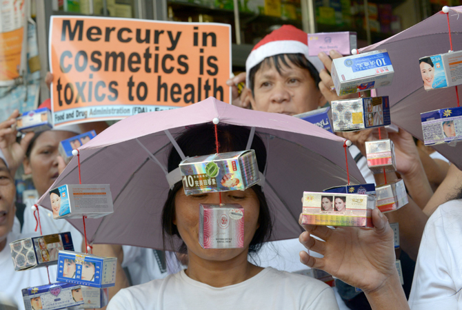 Protestors rally in front of a drug store as they hold allegedly mercury tainted cosmetics in Manila on December 11, 2012. The group urge local traders to stop selling mercury tainted cosmetics that are harmful to people and the environment. – Photo by AFP