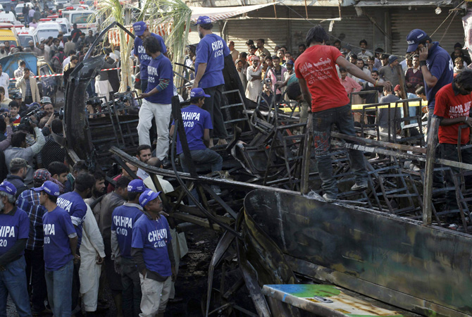 Rescuers search for body parts in a bus after a bomb explosion in Cantonment area, Karachi December 29, 2012. A bomb went off on a bus in the southern Pakistani city of Karachi on Saturday killing six people and wounding 48, police and a hospital official said.?Photo by Reuters