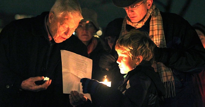 Nine-year-old Jack Noble (C) of Seattle reads the names of the victims of the Sandy Hook Elementary School shooting at a candlelight vigil at Green Lake Park in Seattle December 15, 2012. Twelve girls, eight boys and six adult women were killed in the shooting on Friday at the Sandy Hook Elementary School in Newtown, Connecticut, the state's chief medical examiner said on Saturday. Dressed in “cute kid stuff,” all 20 children died when heavily armed 20-year-old gunman Adam Lanza forced his way into their school, Sandy Hook Elementary, and shot them and six women in an act of violence that has shattered their once-tranquil suburban town. - Photo by Reuters