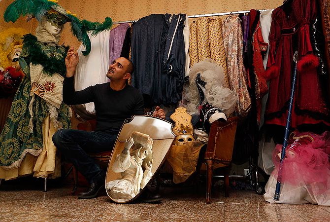 Marco Dilauro gestures next to a mirror with a reflection of his wife Nadia wearing one of his creations. ? Reuters Photo