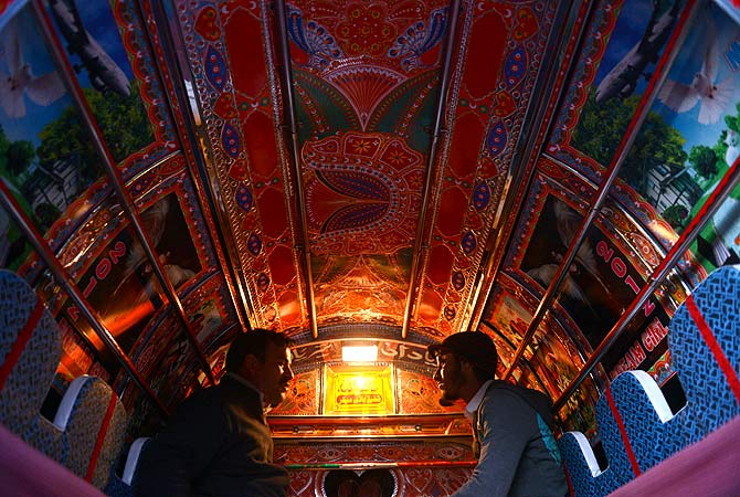 Commuters travel in a decorated minivan in Rawalpindi on January 20, 2013. Many trucks, buses and vans in Pakistan are highly customized and decorated by their owners. These adorned vehicles are considered as moving art, or jingle art, with vehicle owners paying as much as 2,000 USD on decorations. — AFP Photo