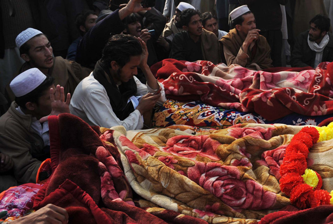 Villagers from the Bara gather around the dead bodies of their relatives during a protest in provincial capital Peshawar on January 16, 2013. – Photo by AFP