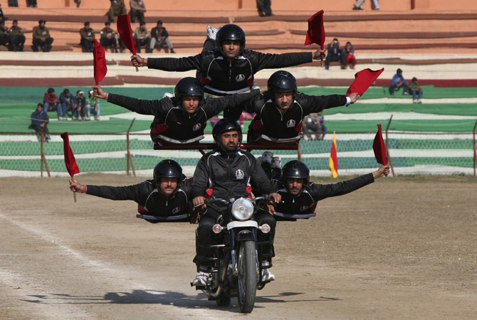 Indian policemen perform a stunt on a motorcycle during the Republic Day parade in Jammu January 26, 2013. India celebrated its 64th Republic Day.