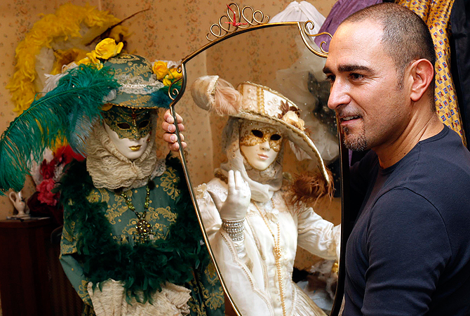 Marco Dilauro looks on as his wife Nadia is reflected in a mirror as she wears one of his creations. ? Reuters Photo