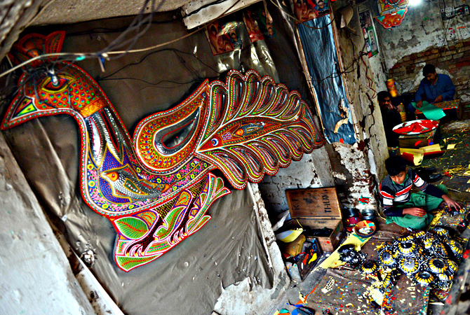 Pakistani artisans work on making decorations for truck and cars, in Rawalpindi. — AFP Photo