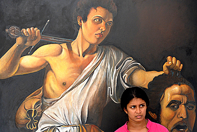 A Sri Lankan woman walks a painting at the annual painting exhibition known as 'Kala Pola' in Colombo ? AFP Photo