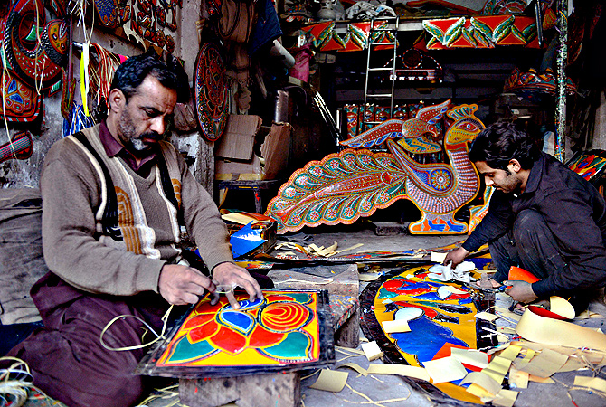 A Pakistani artisan works on making a decoration for a truck or car, in Rawalpindi. — AFP Photo