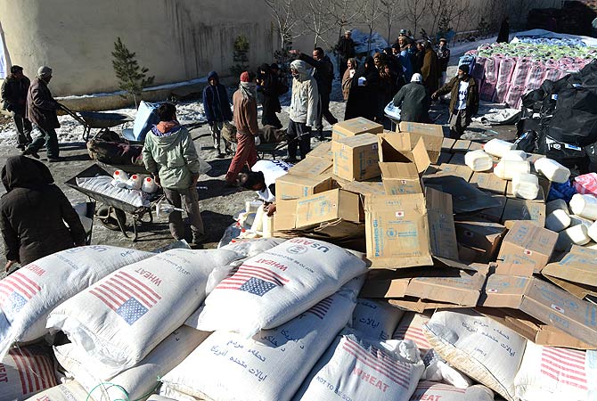 Afghan women and men wait to get winter supplies at a UNHCR distribution centre for needy refugees at the Women's Garden in Kabul on January 2, 2013. ? AFP Photo