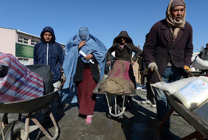 An Afghan woman leaves after receiving winter supplies at a UNHCR distribution centre for needy refugees at the Women's Garden in Kabul on January 2, 2013. ? AFP Photo