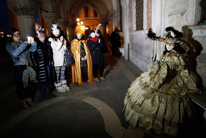 Nadia (R), wife of Marco Dilauro, poses at San Marco Square in Venice, during the Carnival. ? Reuters Photo