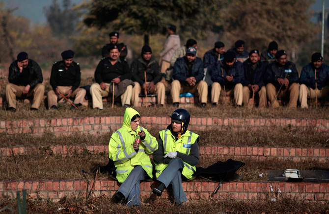 Two Pakistani police officers talk near the Parliament while resting in preparation for a march led by cleric Tahir-ul-Qadri, which is expected to arrive in Islamabad later in the day, in Islamabad, Pakistan, Monday, Jan. 14, 2013. ? Photo by AP