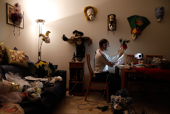 Marco Dilauro looks at one of his creations, a mask he made to wear during the annual Venice Carnival. ? Reuters Photo