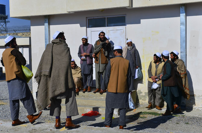 In this picture taken on January 4 ,2013, released Taliban prisoners stand in the sun after a ceremony in Pul-e-Charkhi jail. With tears streaming down their faces, scores of suspected Afghan militants embraced waiting relatives and walked to freedom -- just one sign of increasing attempts at reconciliation after 11 years of war. About 80 men, all wearing white skull caps, were released from jail on January 4, 2013, at a ceremony inside Pul-e-Charkhi, Afghanistan's largest prison located on dusty flatlands east of the capital Kabul. - Photo by AFP