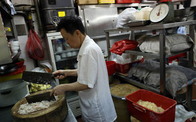 A chef at Ho Hung Kee chopping shrimp with two knives. —Photo by AFP