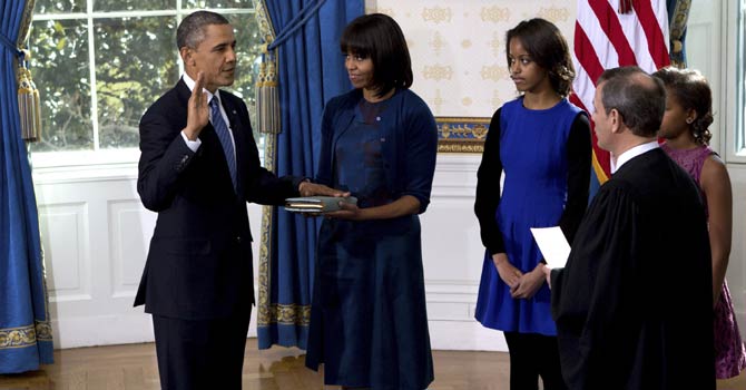 President Barack Obama is officially sworn-in by Chief Justice John Roberts, not pictured, in the Blue Room of the White House during the 57th Presidential Inauguration in Washington, Sunday Jan. 20, 2013, as first lady Michelle Obama, holds the Robinson Family Bible, as daughter Malia and Sasha watch. - AP Photo