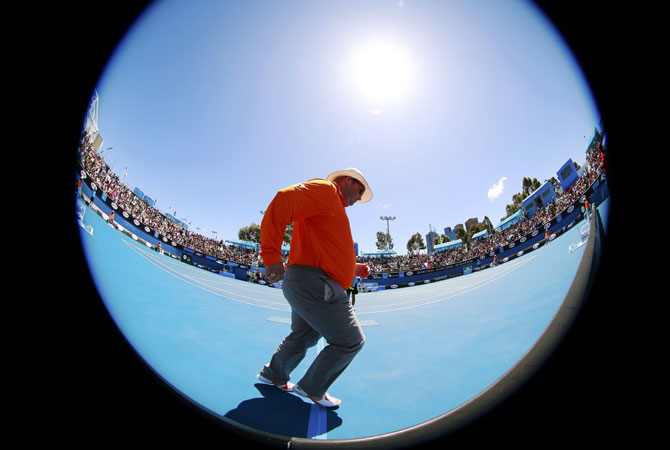 A match official walks on court. -Photo by Reuters