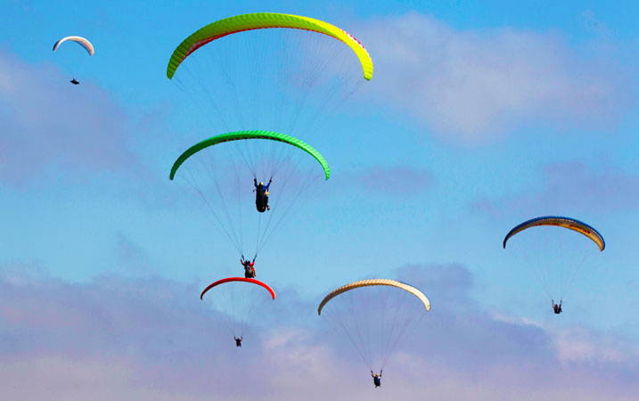 Sport fanatics having a taste of paragliding over the Pacific Ocean. ?Photo by AP