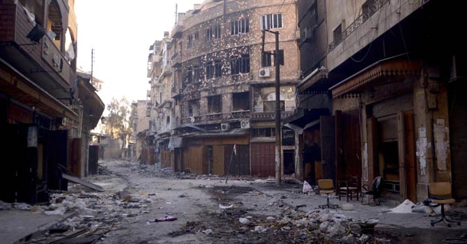 A view shows damaged buildings and an erected Syrian flag in the old city of Aleppo Jan 3, 2013. - Reuters