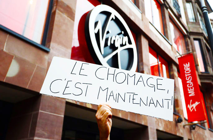 A Virgin Megastore employee holds a sign reading ?Unemployment, it's now? during a demonstration against planned job cuts at the entrance of the store in Strasbourg, eastern France. -Photo by AFP