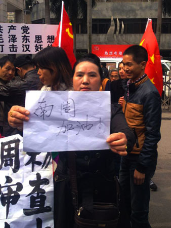 A woman holds a poster reading ?come on, Southern Weekend? to support journalists from the newspaper near their offices in Guangzhou, south China's Guangdong province. Chinese bloggers and celebrities, along with foreign media campaigners, threw their support behind journalists at a newspaper enmeshed in a censorship row, after a rare protest for press freedom. -Photo by AFP